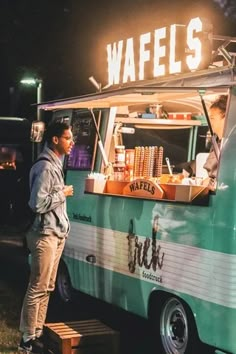 a man standing in front of a food truck with waffles written on it