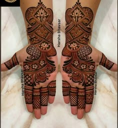 two hands with henna designs on them