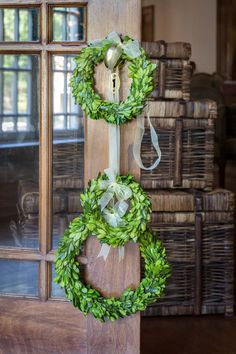 two wreaths are hanging on the front door