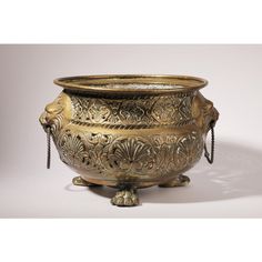 an ornately decorated metal bowl with chains hanging from it's sides and feet