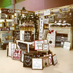 many signs are stacked on top of each other in front of a fireplace and christmas tree