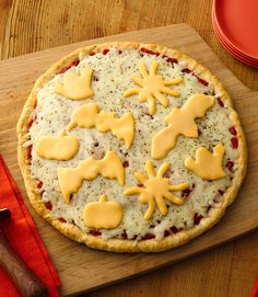 an uncooked pizza with cheese and decorations on it