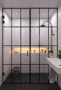 a bathroom with black and white tiled floors and walls, along with a walk in shower