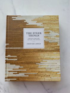 the finer things by christiane leblaer on a marble countertop with gold and white lines