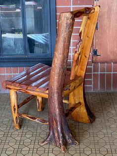 a wooden chair sitting on top of a tiled floor next to a tree stump structure