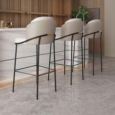 three white bar stools sitting in front of a counter