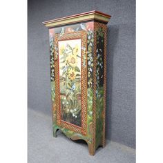 an ornate painted cabinet with flowers on it