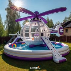 an inflatable pool with a water slide and helicopter shaped house on the top