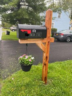 a mailbox with a planter hanging from it's side in the grass