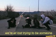 three young people sitting on the side of a road with words written in front of them