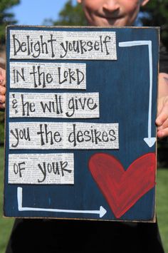 a young boy holding up a sign that says delight yourself in the lord he will give you the desses of your heart