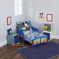 a child's bedroom with mickey mouse bedding and toys