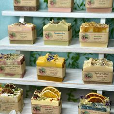 several soaps are displayed on shelves in a display case, with orange slices and flowers