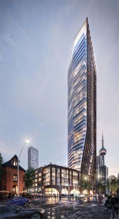 a very tall building sitting in the middle of a street next to some cars and buildings