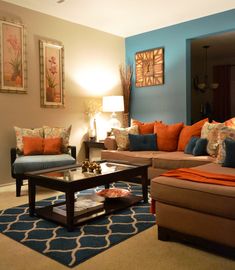 a living room filled with lots of furniture next to a wall mounted painting on the wall