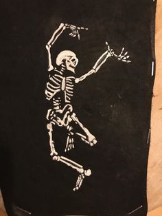 a drawing of a skeleton is shown on a piece of black paper