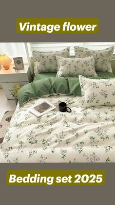 the bedding set is made up with green and white flowers on it, along with a black coffee mug