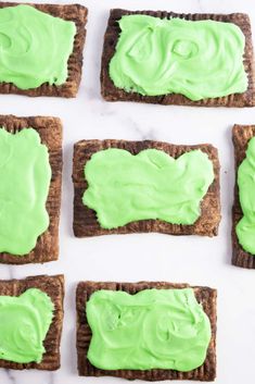 green icing on top of crackers in the shape of faces