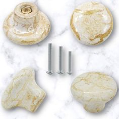 four marble knobs and two screws on a white marble surface