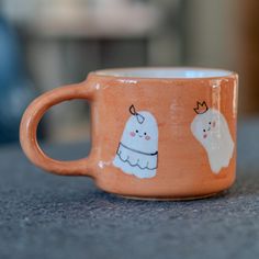 an orange coffee cup with two white dogs on it