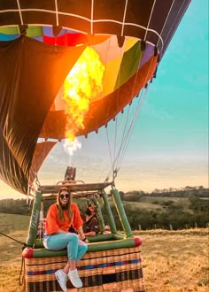 a woman sitting on top of a hot air balloon