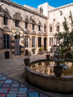 an old courtyard with fountain and potted plants