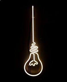 a neon light bulb hanging from the side of a black wall with a white cord attached to it