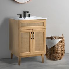 a bathroom with a sink, mirror and wicker basket on the floor next to it