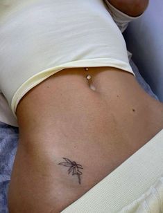 a woman's stomach with a small tattoo on her belly and the bottom part of her abdomen