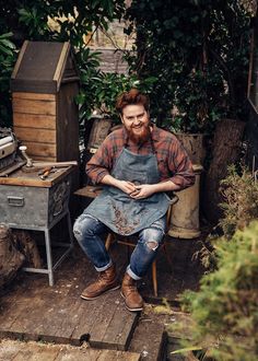 a man sitting in a chair with an apron on