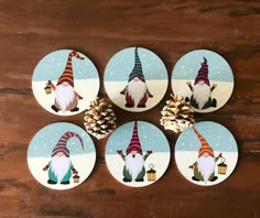 six gnomes with pine cones on them are sitting in front of a wooden table