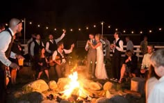 a group of people standing around a fire pit