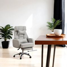 an office chair sitting in front of a desk with a potted plant on it