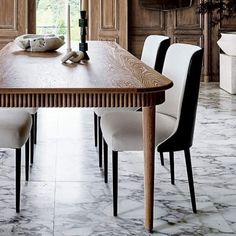 a dining room table with white chairs around it