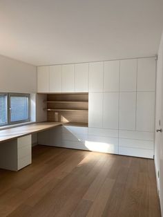 an empty room with wooden floors and white walls