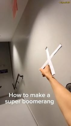 someone is holding a paper airplane in their hand and pointing it at the wall with text that reads, how to make a super boomerang