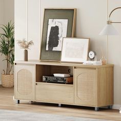 a living room with an entertainment center and pictures on the wall next to a lamp