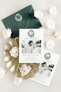 the wedding stationery is laid out on top of some gold coins and white flowers