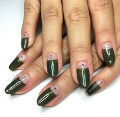 a woman's hands with green and pink nail polishes on their nails,