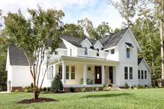 a large white house sitting on top of a lush green field