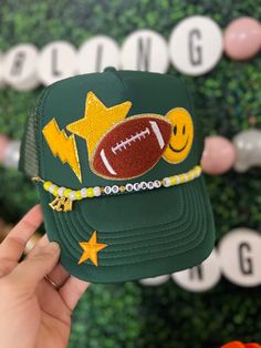 Friday Night Lights hair? Don't care!  Every football mom needs one of our custom trucker hats to wear on Friday nights. I also have different colored footballs, baseballs, soccer balls, hockey sticks, volleyballs and basketballs!   All our hats are totally customizable, so message us to request custom colors or patches. We can build a custom listing just for you! Custom Ball Hat, School Hats, Football Trucker Hat With Patches, Football Accessories Ideas, Adjustable Green Baseball Cap For Sports Events, Customizable Sports Fan Trucker Hat, Adjustable Customizable Sports Fan Hat, Customizable Green Baseball Cap, Customizable Adjustable Trucker Hat For Sports Fans