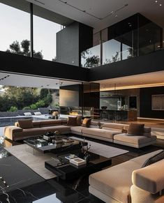 modern living room with large couches and black marble coffee table in front of glass windows