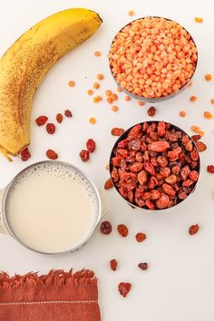 cereal, milk, and banana on a white surface with other foods in small bowls