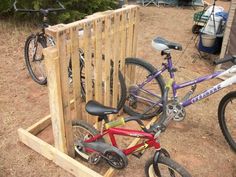 two bikes parked next to each other in front of a wooden fence