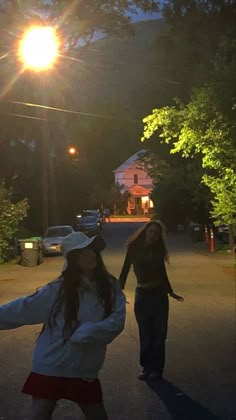 two girls are walking down the street at night