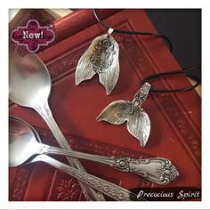 three silver spoons and two pendants on a red book with the words precious spirit