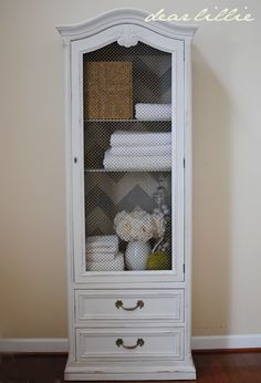 a white cabinet with drawers and baskets on top