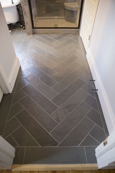 a bathroom with gray tile flooring and white walls