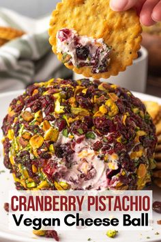 cranberry pistachio vegan cheese ball on a plate with crackers