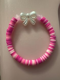 a pink and white bracelet with a bow on it